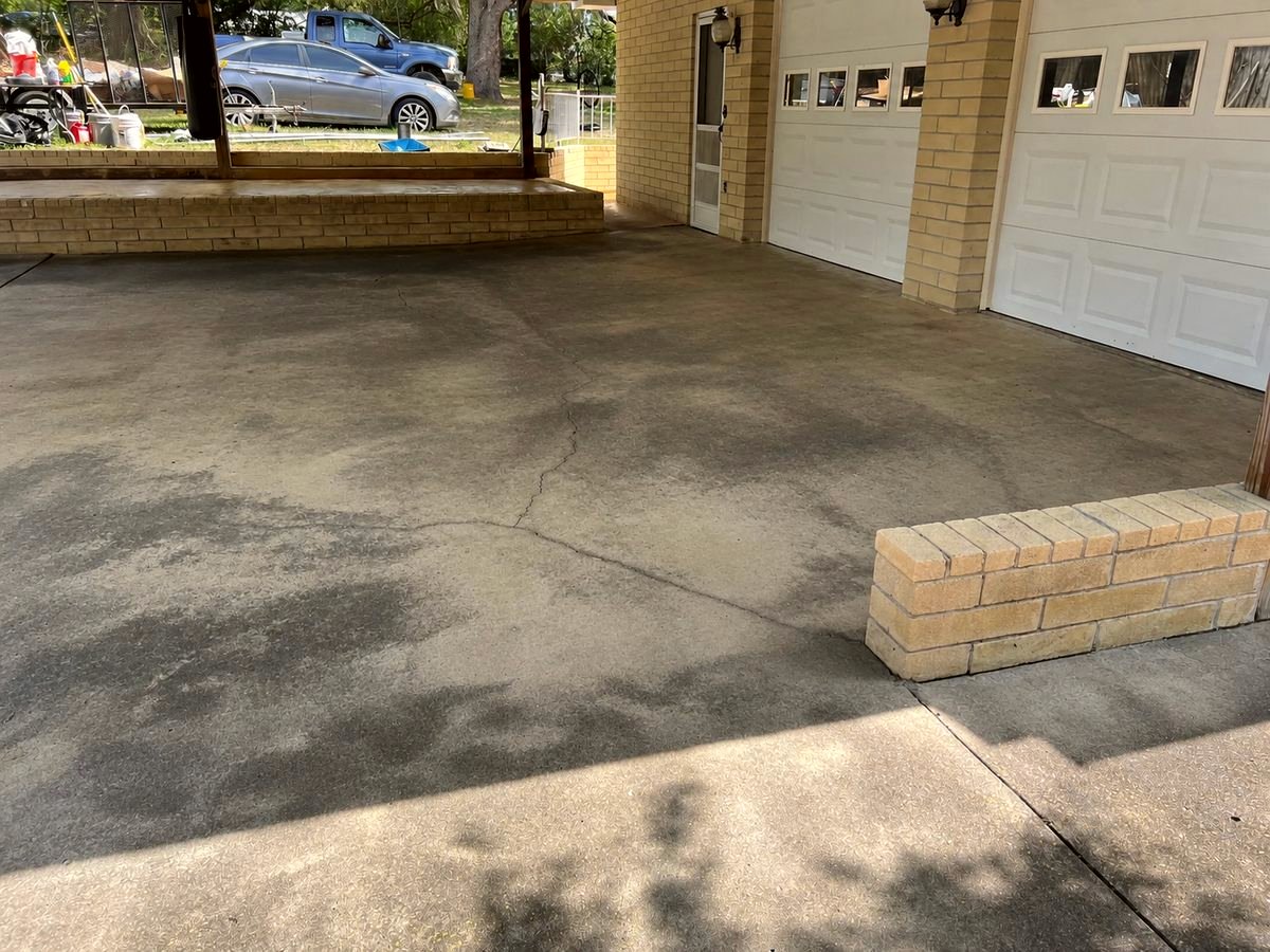 Bare concrete carport floor before staining